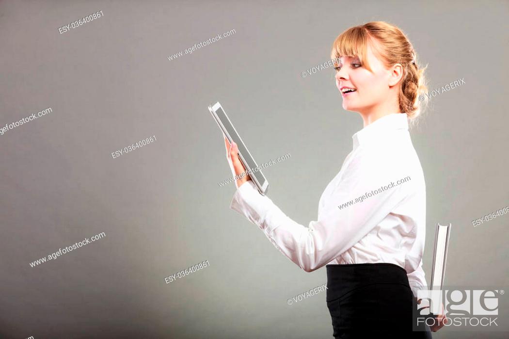 Stock Photo: Woman learning with ebook tablet holding book behind back. Choice between modern educational technology and traditional way method.