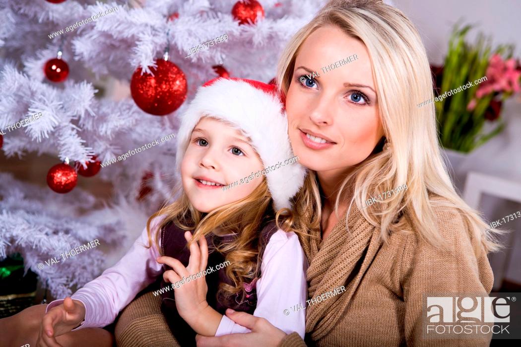 Stock Photo: Mother and daughter in front of Christmas tree.