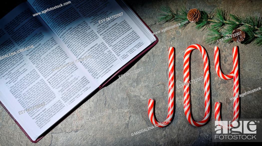 Stock Photo: Open Bible and Joy Written With Candy Canes On Stone Table.