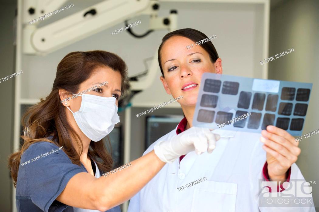 Stock Photo: Dentist and assistant looking at x-ray.