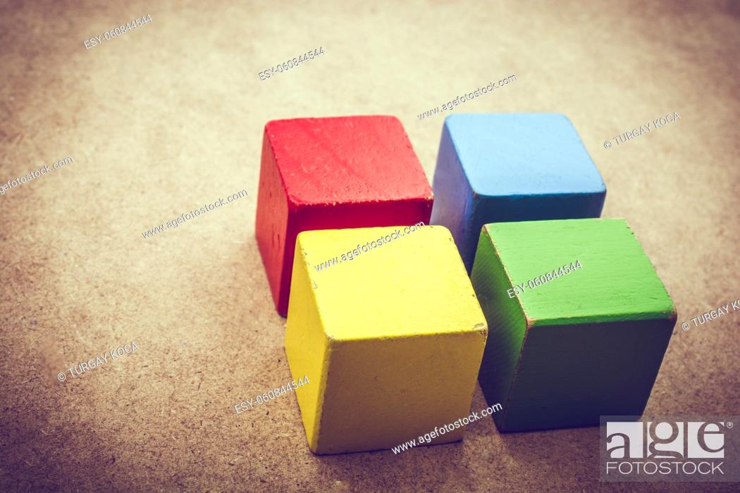 Stock Photo: Colorful building blocks on a brown background.
