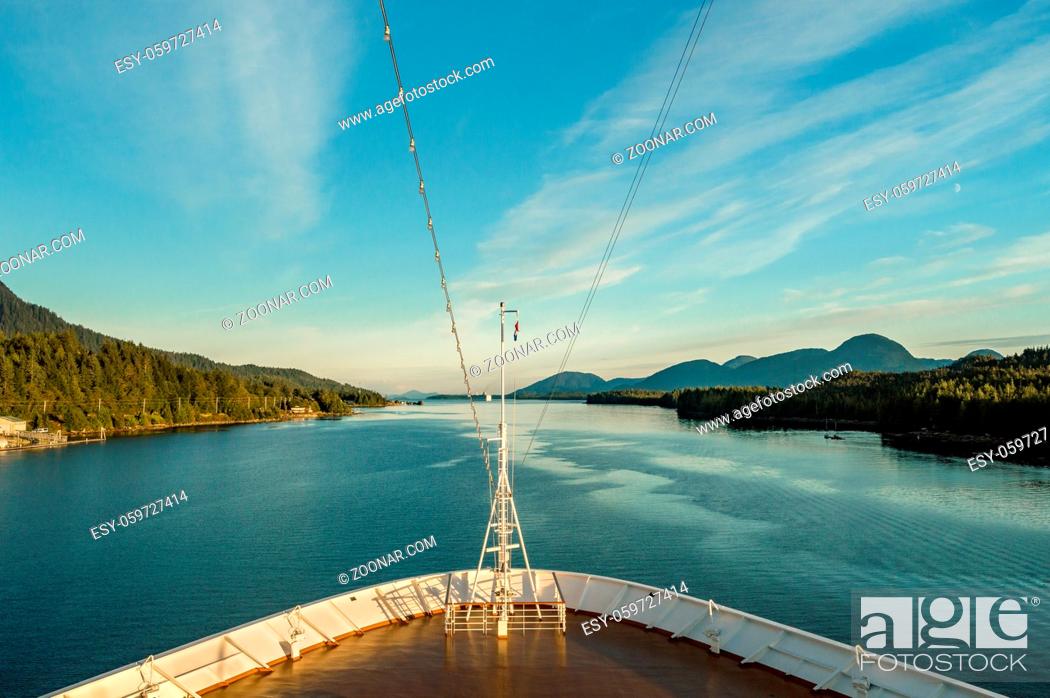 Stock Photo: Pointed white bow of cruise ship , southbound on ocean channel, Alaska Inside Passage, in warm afternoon sun, upper outside deck.