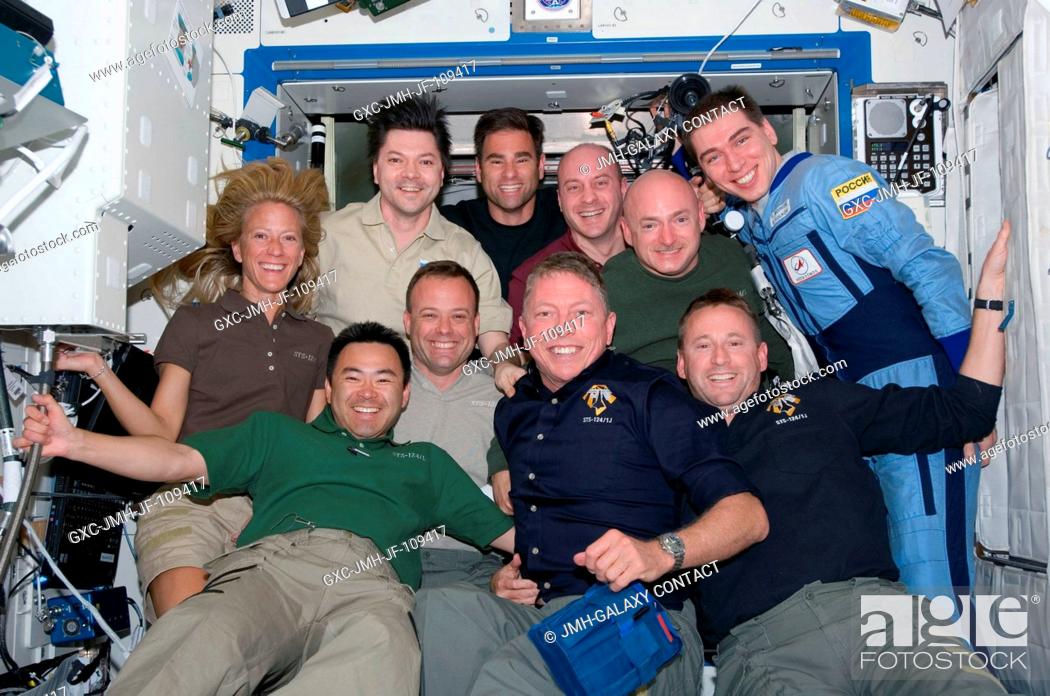 Stock Photo: The STS-124 and Expedition 17 crewmembers pose for a group portrait in the Destiny laboratory of the International Space Station while Space Shuttle Discovery.