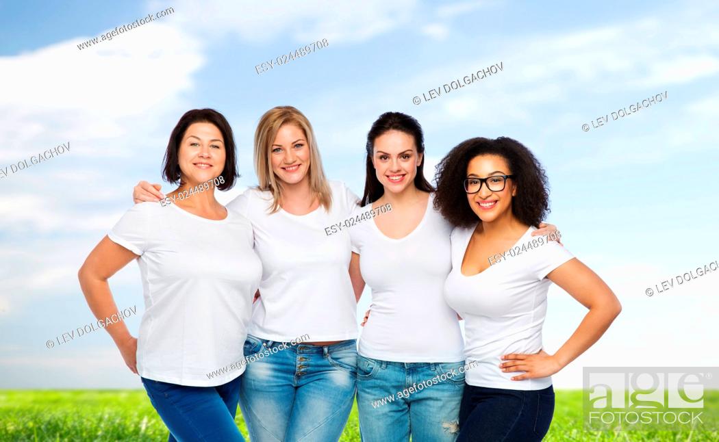 Stock Photo: friendship, diverse, body positive and people concept - group of happy different size women in white t-shirts hugging over blue sky and grass background.