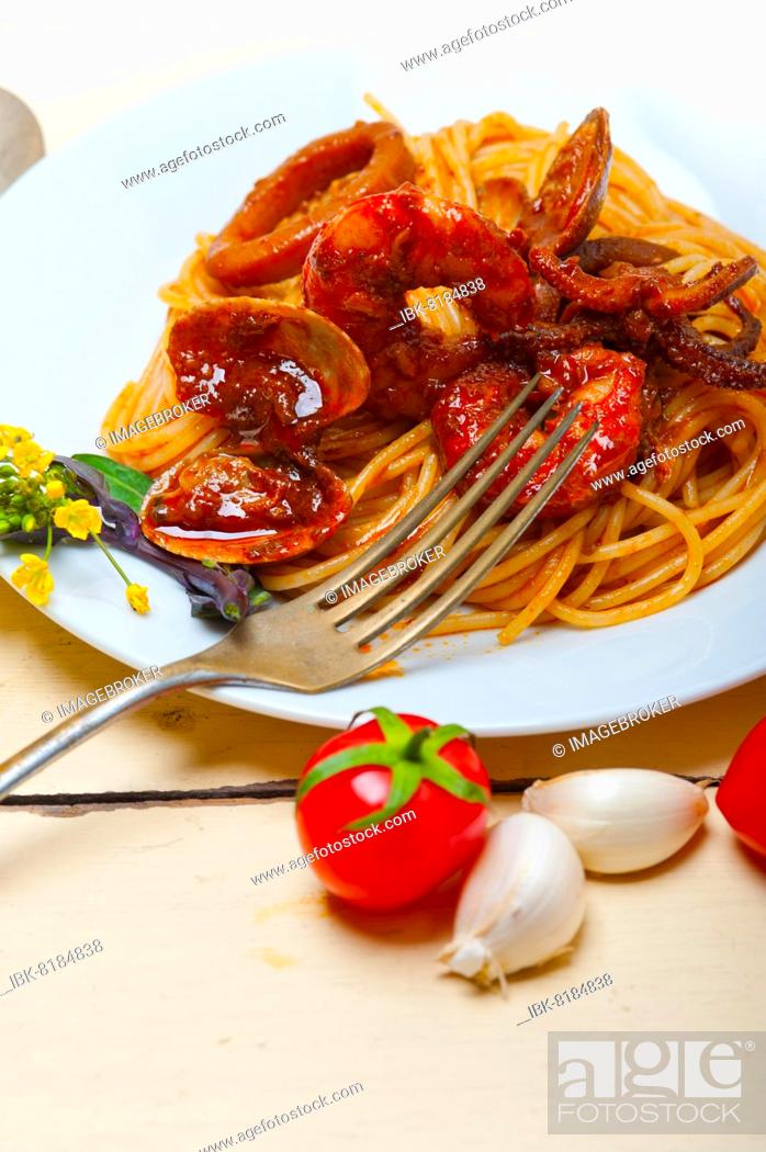 Photo de stock: Italian seafood spaghetti pasta on red tomato sauce over white rustic wood table.