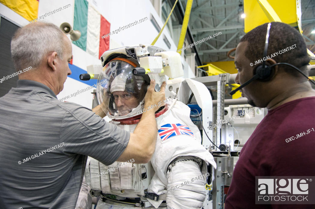 Stock Photo: European Space Agency astronaut Timothy Peake, Expedition 4647 flight engineer, gets help making final touches on a training version of his Extravehicular.