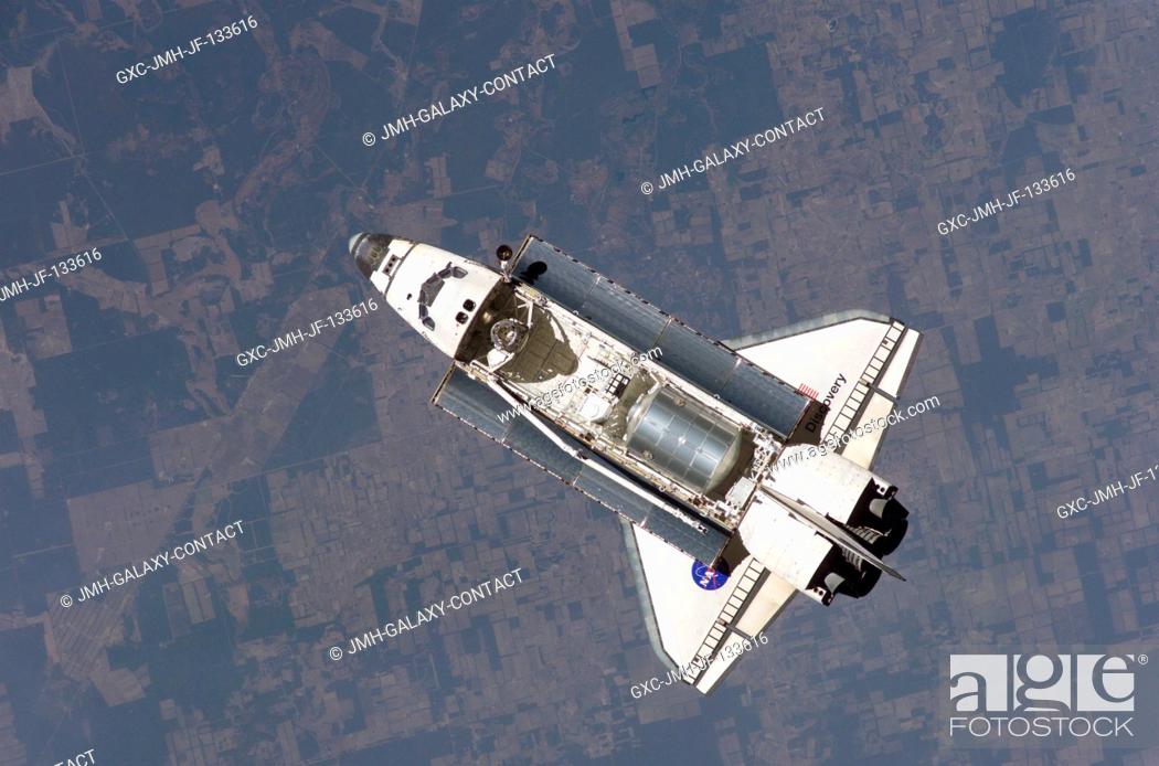 Stock Photo: The Space Shuttle Discovery approaches the International Space Station for docking but before the link-up occurred, the orbiter posed for a thorough series of.