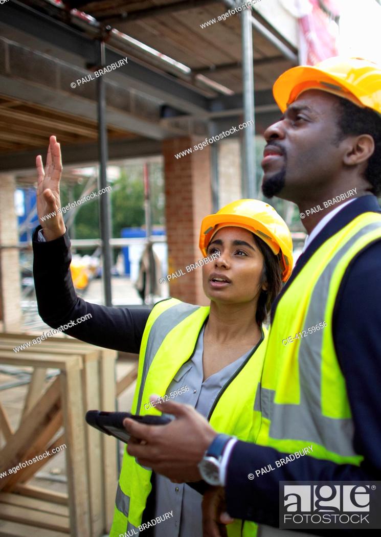 Photo de stock: Engineers with digital tablet talking at construction site.