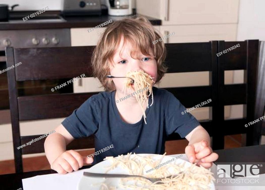 Stock Photo: Süßes Kind mit dem Mund voll Nudeln.