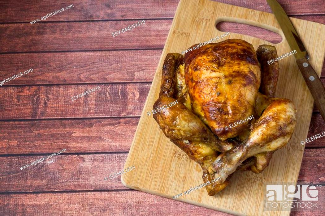 Stock Photo: Heavily roasted grilled Chicken on wooden background.