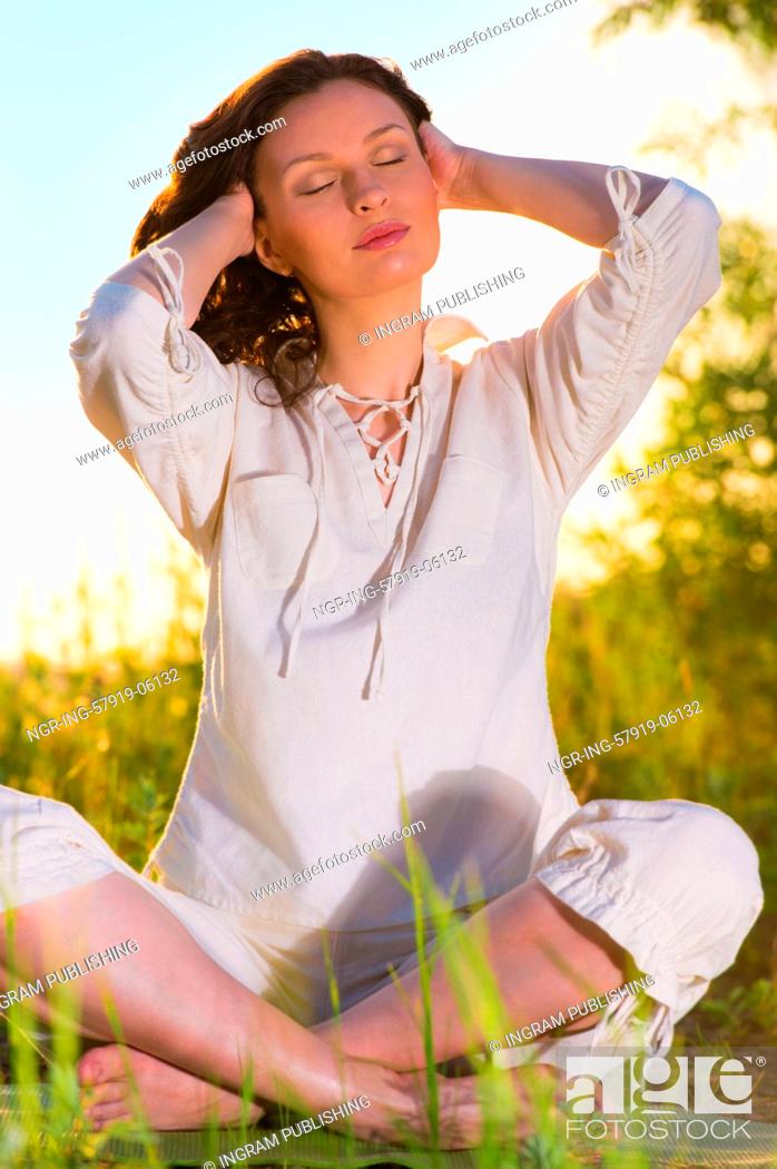 Stock Photo: Stretching woman in outdoor exercise smiling happy doing yoga stretches. Beautiful happy smiling sport fitness model outside on summer / spring day.
