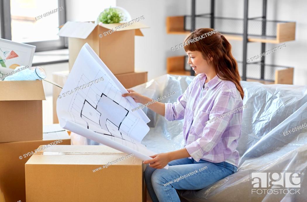 Imagen: woman with blueprint and boxes moving to new home.