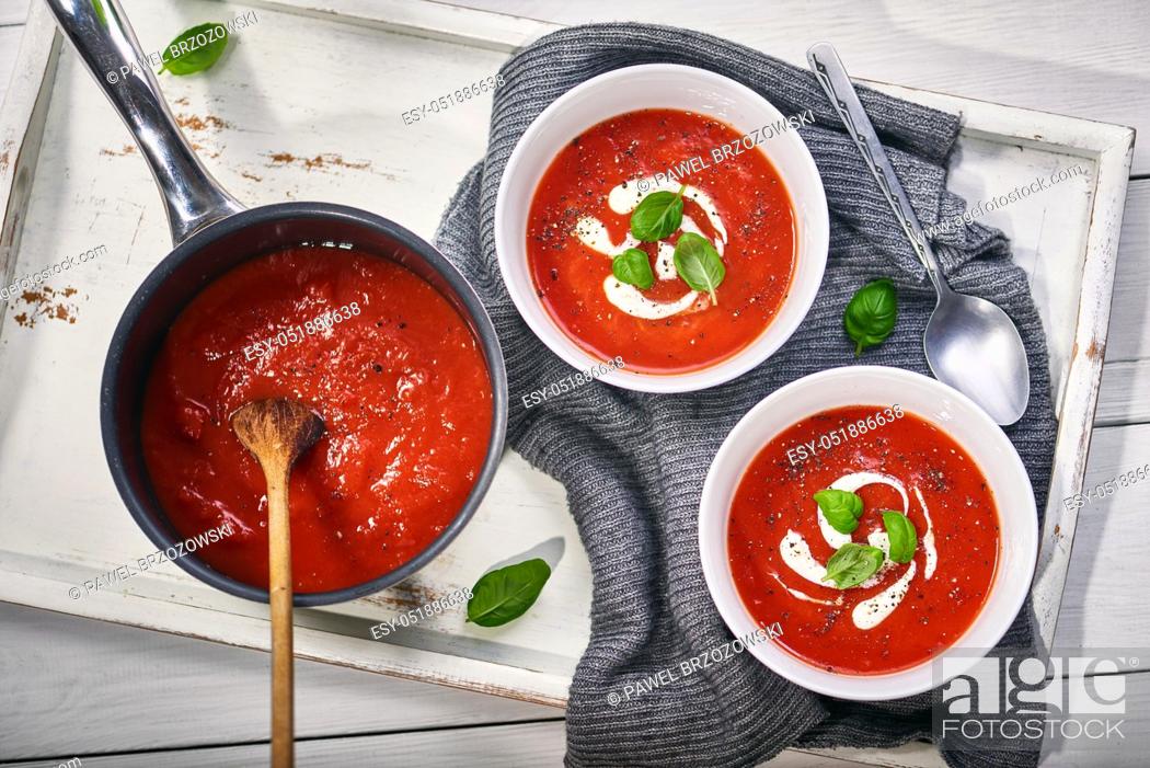 Stock Photo: Tomato cream soup with sour cream and basil.