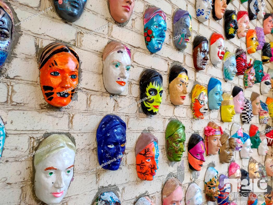 Stock Photo: Moscow, Russia, 21 October 2019: Colorful painted ceramic faces sculpture on the bricks wall as an the object of modern art.