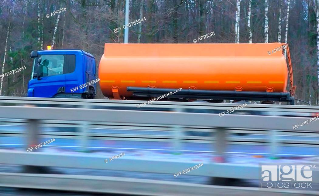 Stock Photo: fuel truck with the orange tank goes on the winter highway.