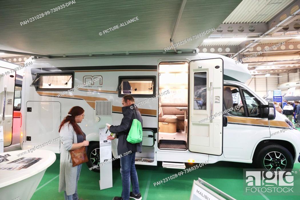 Stock Photo: 28 October 2023, Thuringia, Erfurt: Visitors get information about a motorhome from the manufacturer Malibu at the stand of ""Faha Cars & Caravans"" at the.