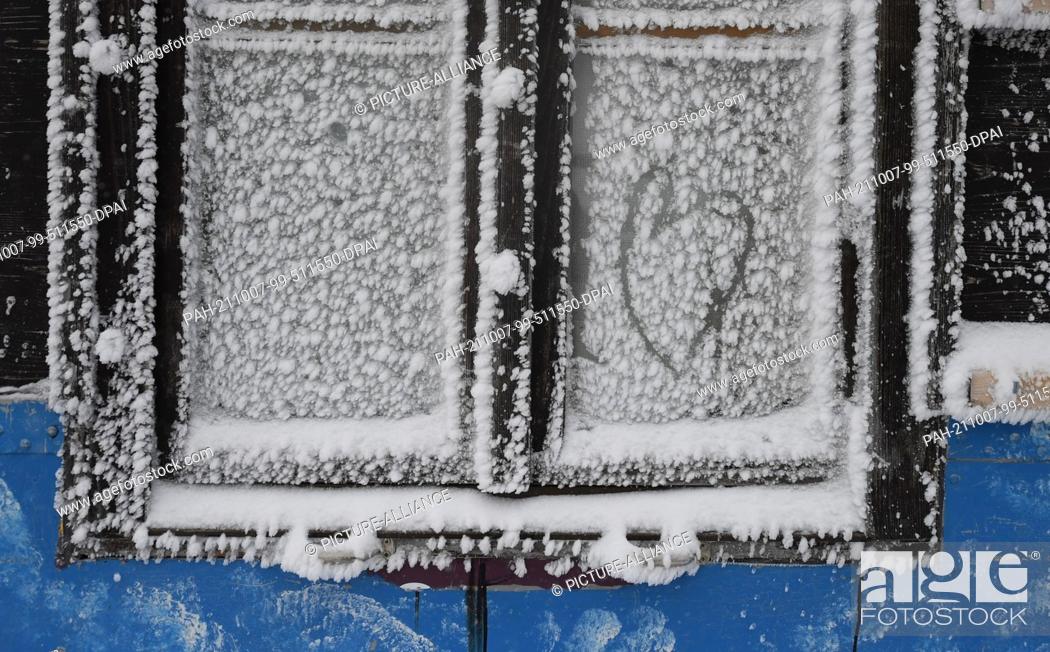 Stock Photo: 07 October 2021, Bavaria, Grainau: A heart was painted in a snow-covered window on the roof terrace of the Zugspitze mountain station.