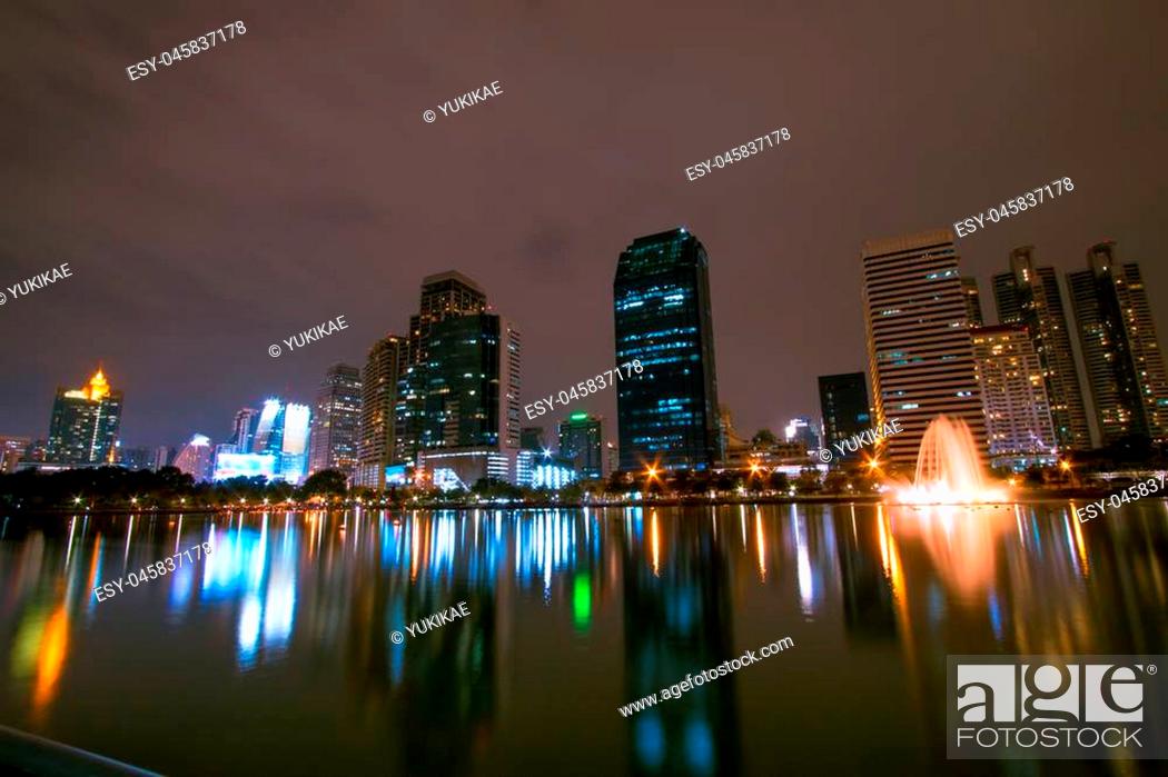 Stock Photo: Golden reflection light in lake and Night view of Bangkok downtown at Benja kitti park, Thailand.