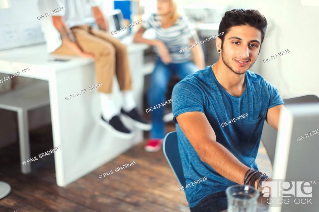 Stock Photo: Portrait confident creative young businessman working at computer.