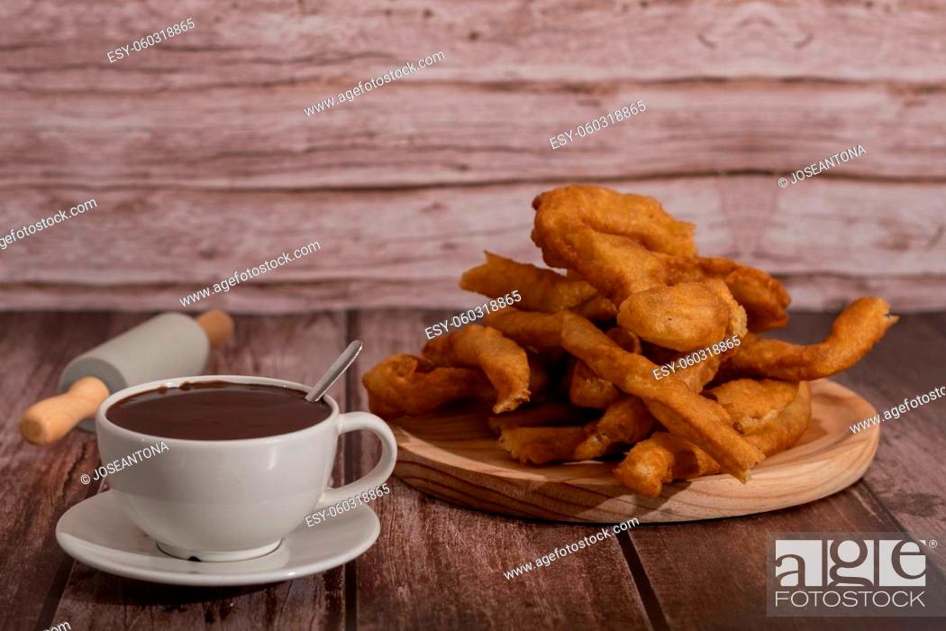 Stock Photo: cup of hot chocolate with freshly made churros on wooden background typical spanish breakfast on holidays.