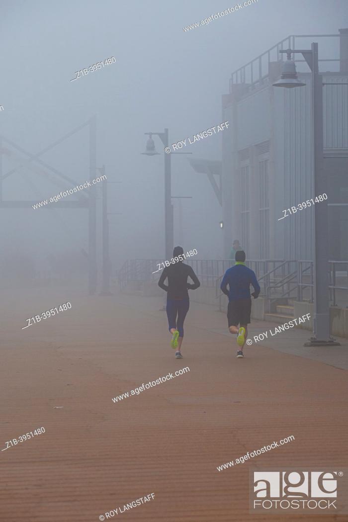 Stock Photo: Two people running in fog along the Steveston waterfront British Columbia Canada.