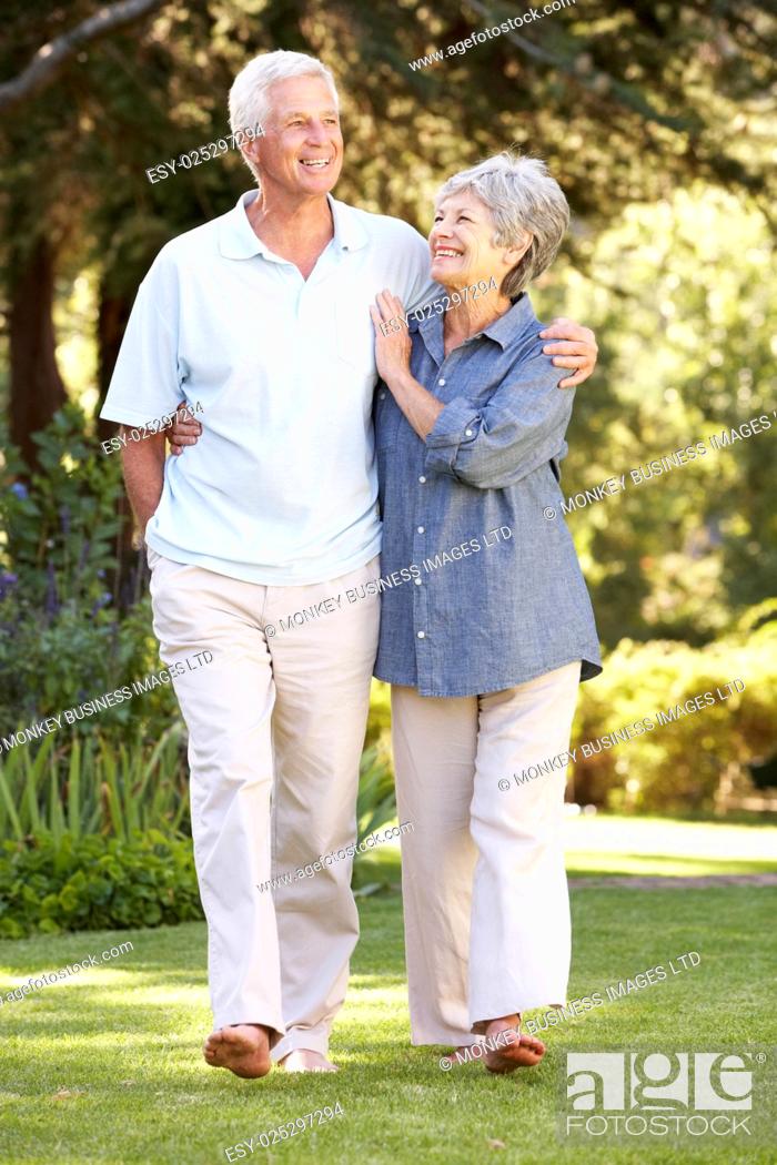 Stock Photo: Senior Couple Walking In Garden At Home.