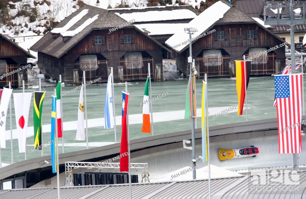 Stock Photo: The four-person Bob with Rico Peter, Alex Baumann, Simon Friedli and Janne Bror van der Zijde from Switzerland on the echo-curve lined with flags in Schoenau Am.