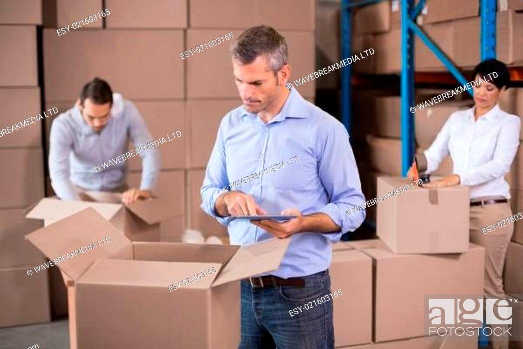 Imagen: Warehouse workers packing up boxes.