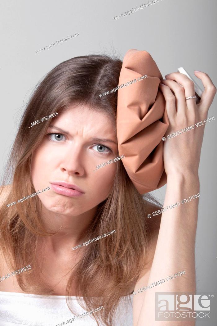 Stock Photo: young woman with an ice pack on his head.