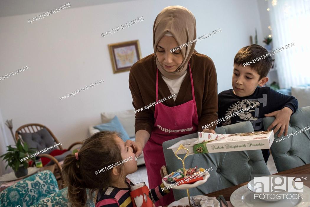 Stock Photo: PRODUCTION - 10 May 2021, North Rhine-Westphalia, Minden: Hatice Bahadir gives her children sweets. During the day, believers in Ramadan do not eat anything;.
