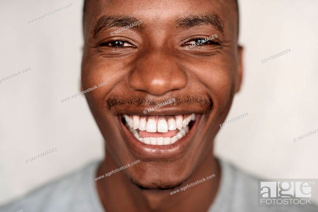 Stock Photo: Closeup portrait of a carefree young African man in a t-shirt laughing at home.