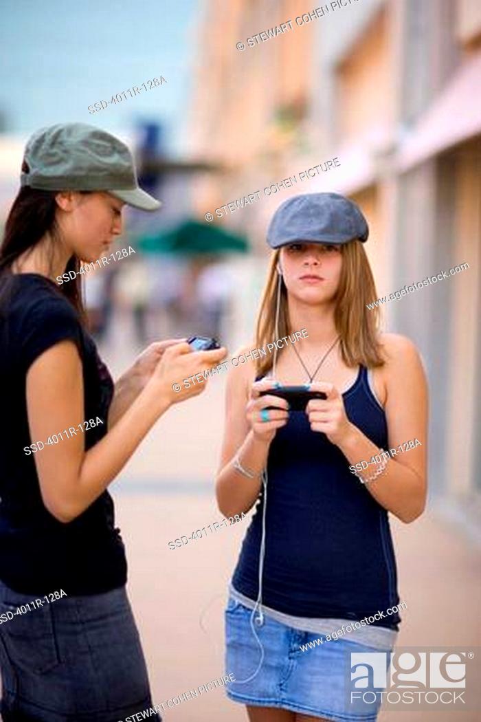 Imagen: Two female friends listening to MP3 players.