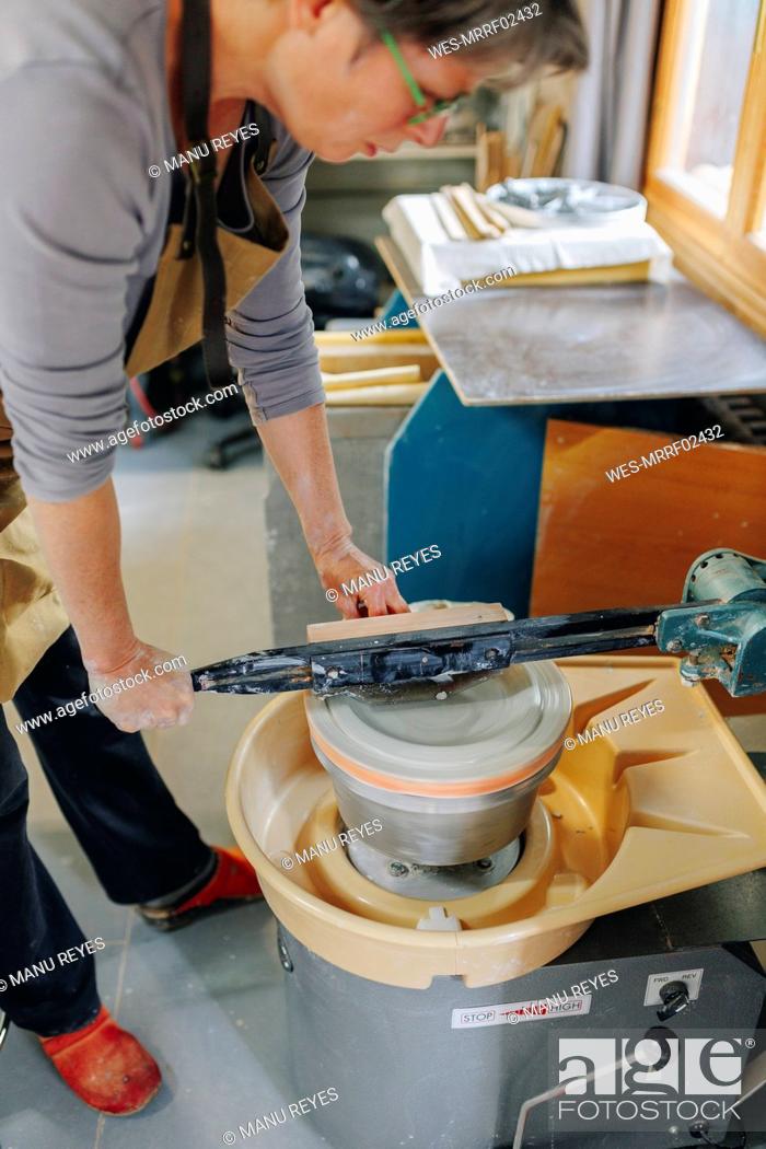 Photo de stock: Potter making ceramics on pottery wheel at workshop.