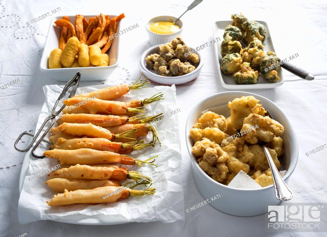 Stock Photo: Beer batter vegetables served with croquettes and sweet potato fries with dip (vegan).
