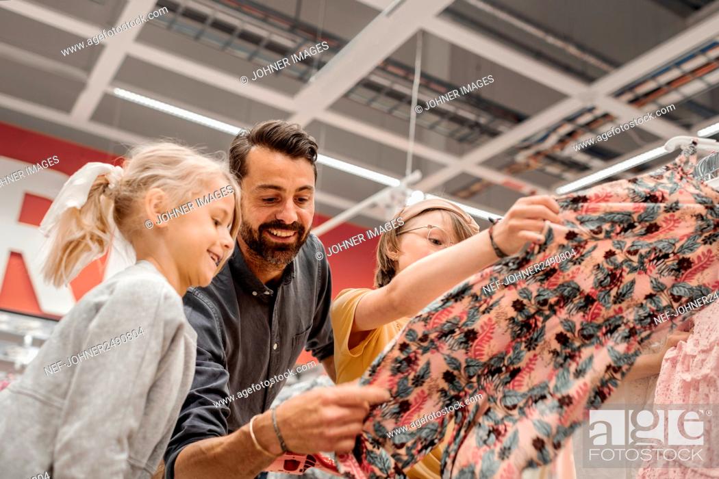 Stock Photo: Father with daughters in shop.