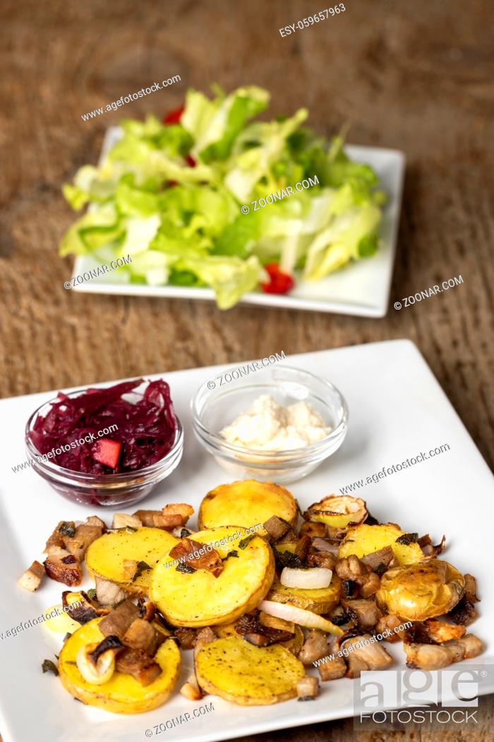 Stock Photo: bavarian groestl with salad on wood.
