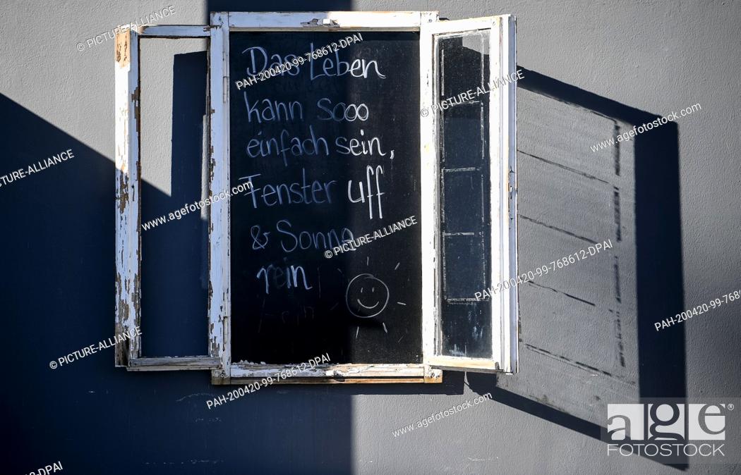 Stock Photo: 20 April 2020, Berlin: On a blackboard is written ""Life can be so simple, windows uff and sun pure"" as a motto in times of the corona crisis.