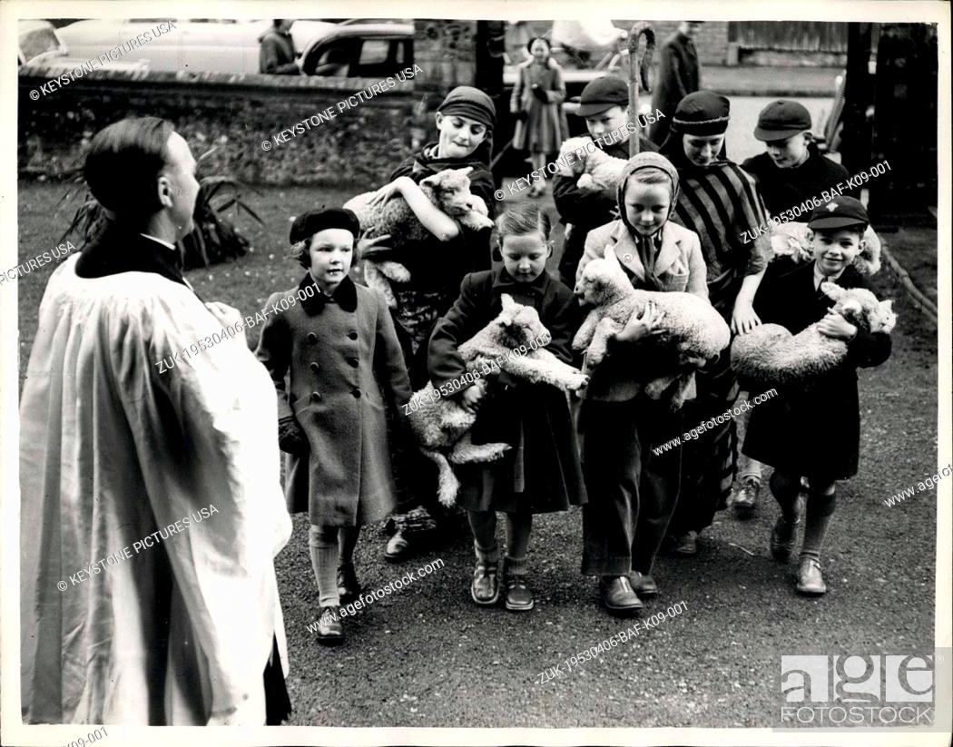 Stock Photo: Apr. 06, 1953 - Lambs go to Church : The Rev. John Hughes smiles a welcome from the church door, as children arrive with six lambs - in -arms.