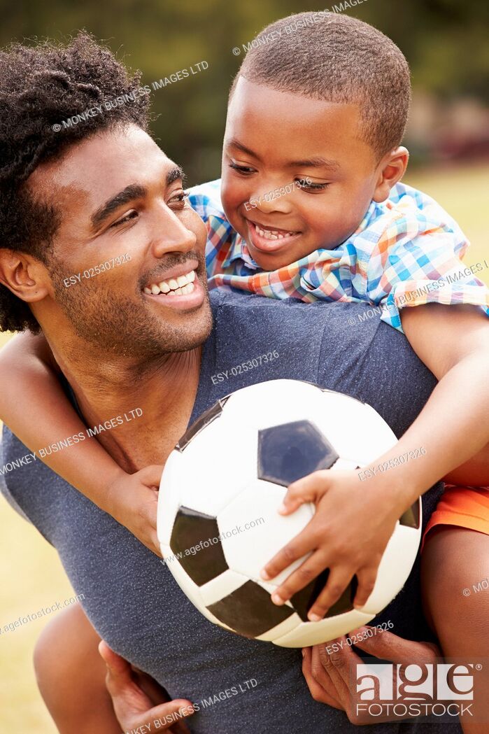 Stock Photo: Father With Son Playing Soccer In Park Together.