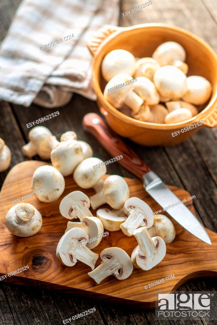 Stock Photo: Fresh white champignon mushrooms on cutting board.