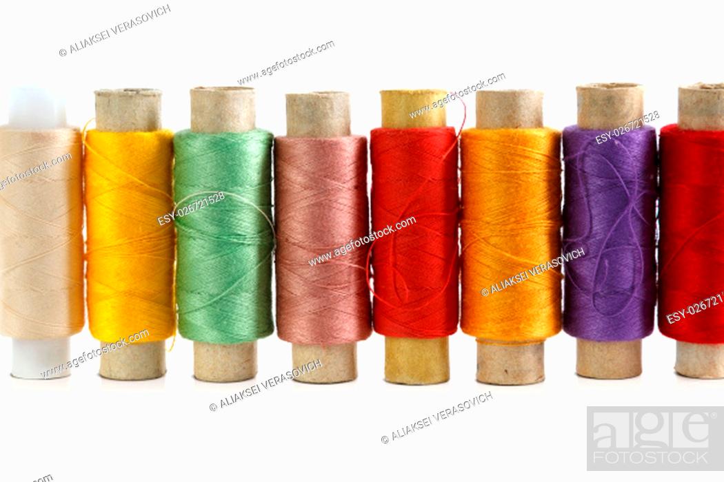 Stock Photo: Several spools of brightly colored threads on a white background.