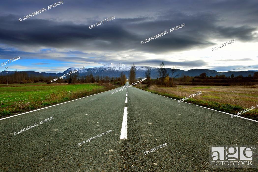 Photo de stock: Road and snow mountains in the background in the Tobalina Valley, Burgos, Spain.