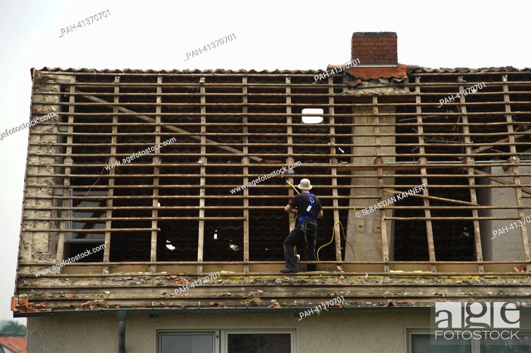 Stock Photo: A roofer stands in a destroyed roof truss in Sehnde, Germany, 29 July 2013. A violent storm with hail tracked over the region Hanover on Saturday evening and.