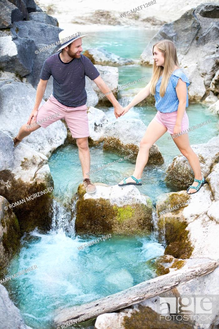 Stock Photo: Young couple crossing river.