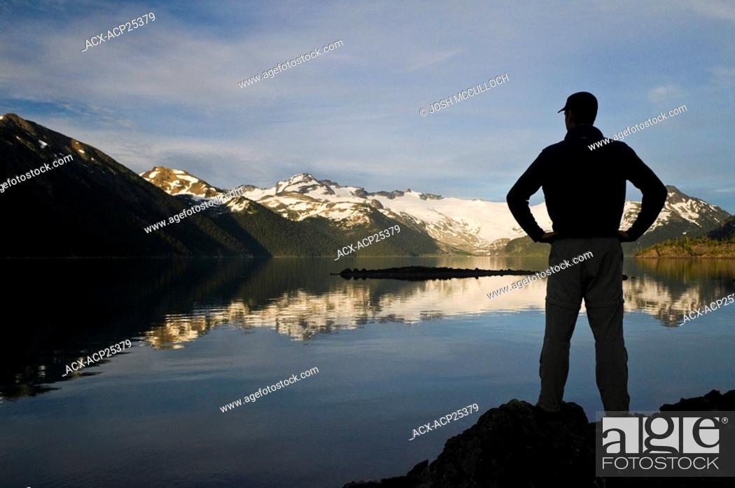Stock Photo: A hiker is silhouetted by the Sphinx Glacier at Garibaldi Lake in Garibaldi Provincial Park near Whistler BC.
