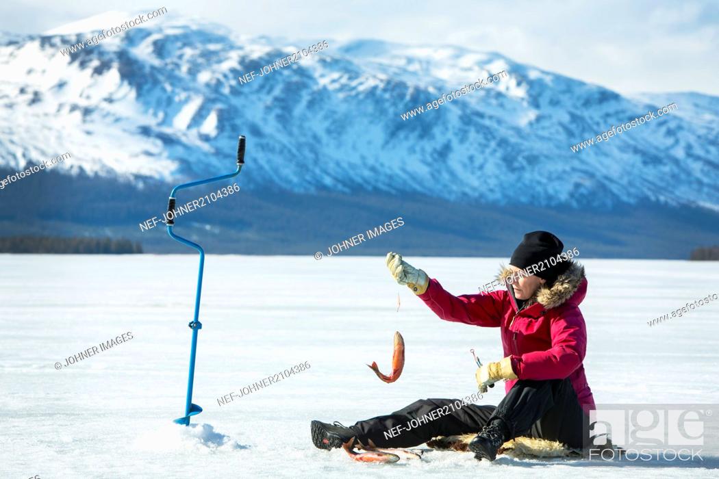 Stock Photo: Woman ice fishing.