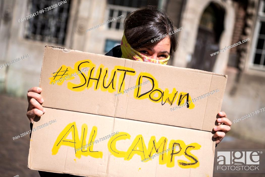 Stock Photo: 17 April 2020, Bremen: A demonstrator holds a poster saying ""Shut down all camps"". During a demonstration, the closure of the central initial reception point.