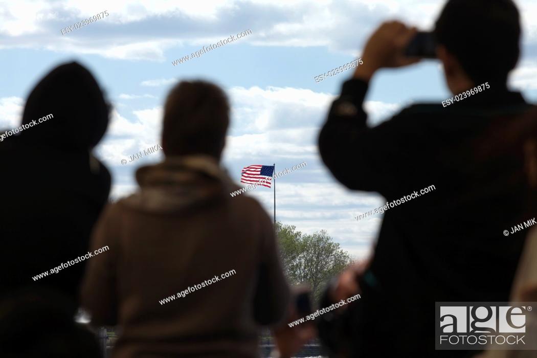 Stock Photo: Silhouettes of travelers looking at the flag of the United States of America.