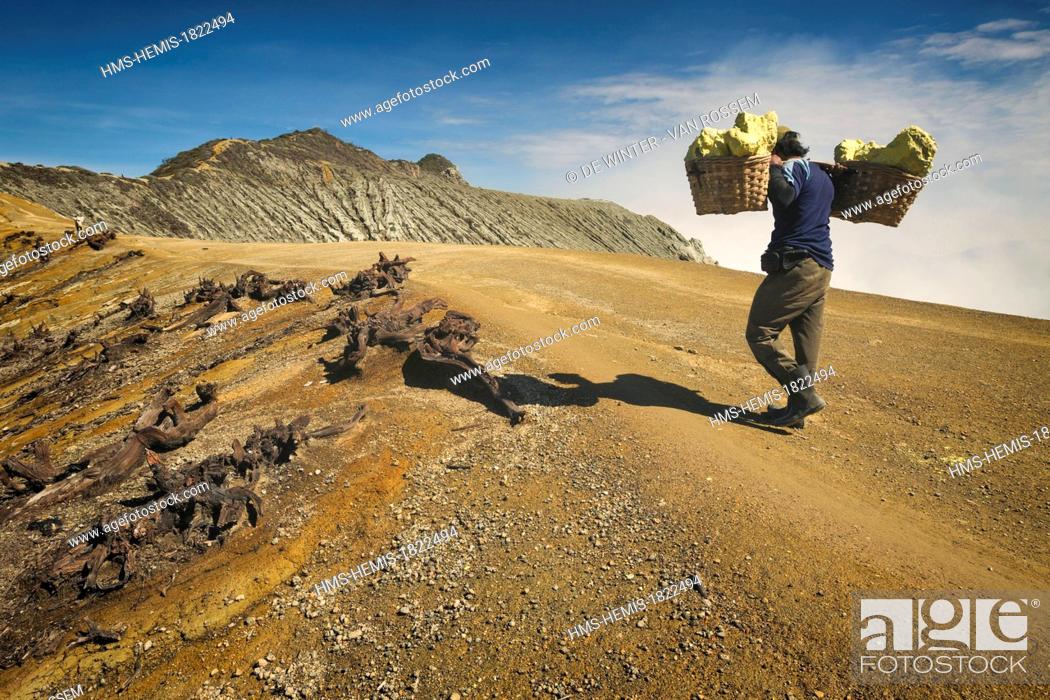 Stock Photo: Indonesia, Java, Kawah Ijen, sulphur mine worker carrying heavy loads of sulphur in a basket.