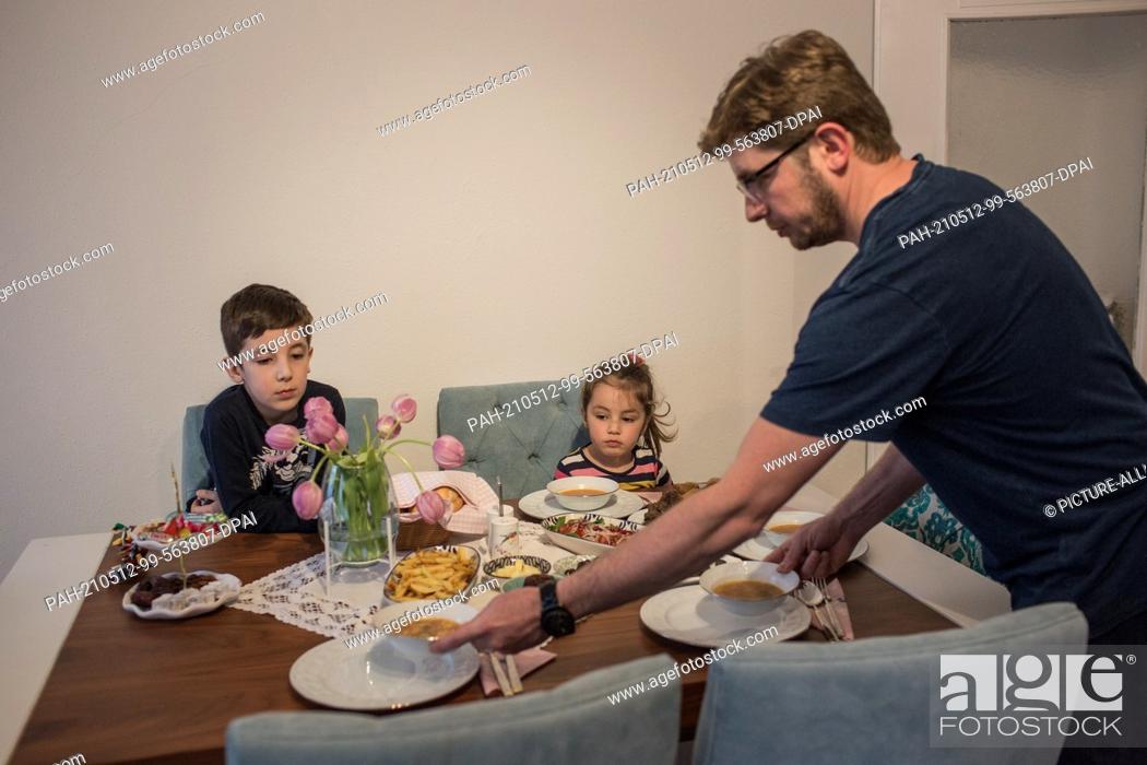 Stock Photo: PRODUCTION - 10 May 2021, North Rhine-Westphalia, Minden: Abdurrahman Bahadir and her children have an iftar (breaking of the fast) meal together in their home.
